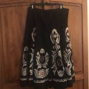Black skirt with silver and red embroidery.